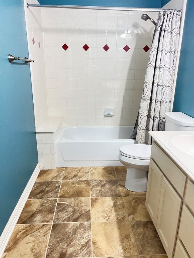2210 Fairlands Dr, Garland, TX 75040 - bathroom with stone finish floor, toilet, vanity, baseboards, and shower / tub combo