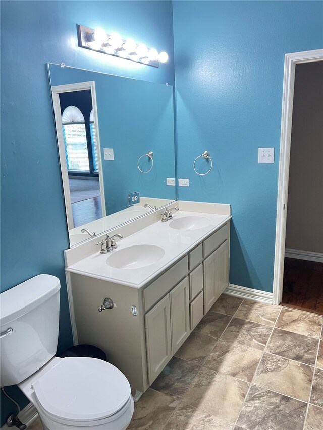 2210 Fairlands Dr, Garland, TX 75040 - bathroom with stone finish floor, double vanity, toilet, and a sink