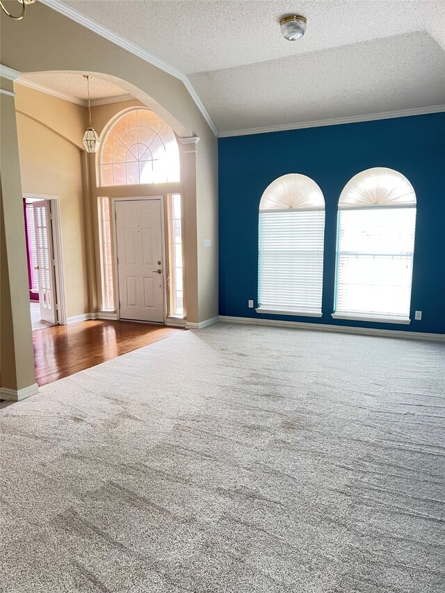 2210 Fairlands Dr, Garland, TX 75040 - carpeted foyer entrance featuring baseboards, a textured ceiling, ornamental molding, and a healthy amount of sunlight