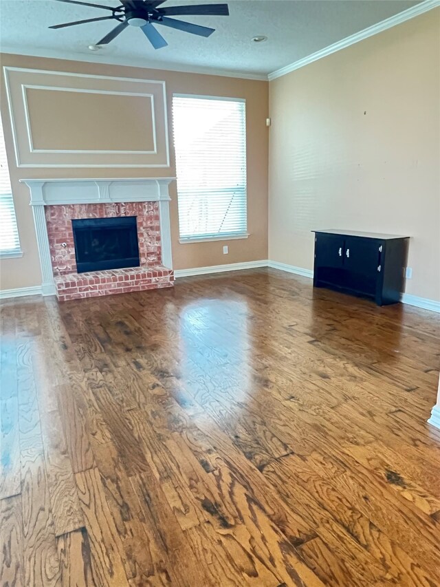 2210 Fairlands Dr, Garland, TX 75040 - unfurnished living room featuring baseboards, a ceiling fan, wood finished floors, a brick fireplace, and ornamental molding