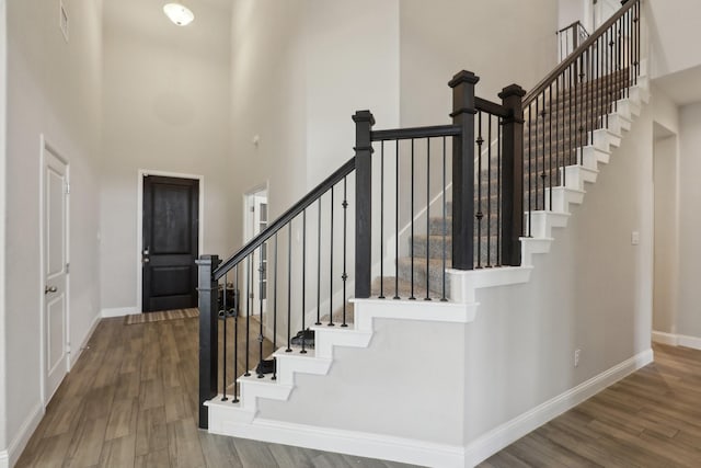 3651 Rainwater Trl, Grand Prairie, TX 76065 - stairway with a towering ceiling, baseboards, and wood finished floors
