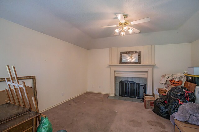 living room with a ceiling fan, carpet, a fireplace, baseboards, and a raised ceiling