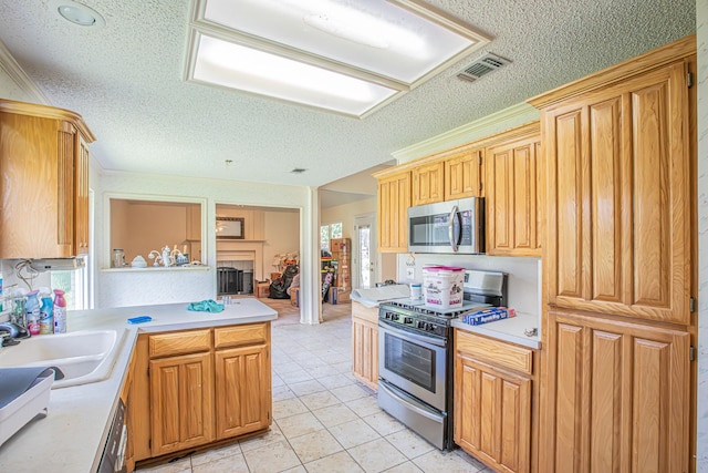 kitchen featuring light countertops, a textured ceiling, appliances with stainless steel finishes, and visible vents