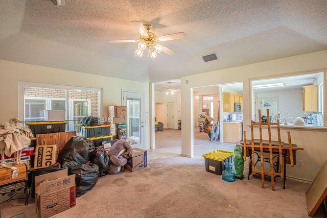 interior space featuring visible vents, carpet flooring, a textured ceiling, and multiple windows