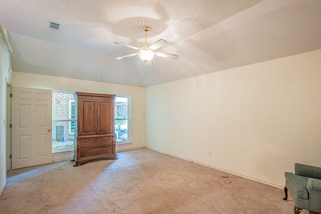 interior space with a textured ceiling, baseboards, light colored carpet, lofted ceiling, and visible vents