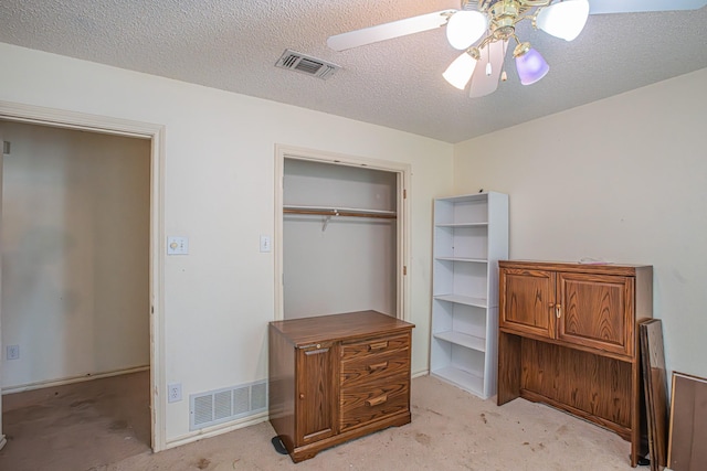 unfurnished bedroom featuring ceiling fan, light carpet, visible vents, and a closet