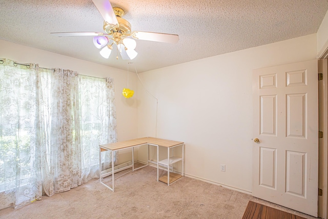 interior space with carpet, a textured ceiling, and a ceiling fan