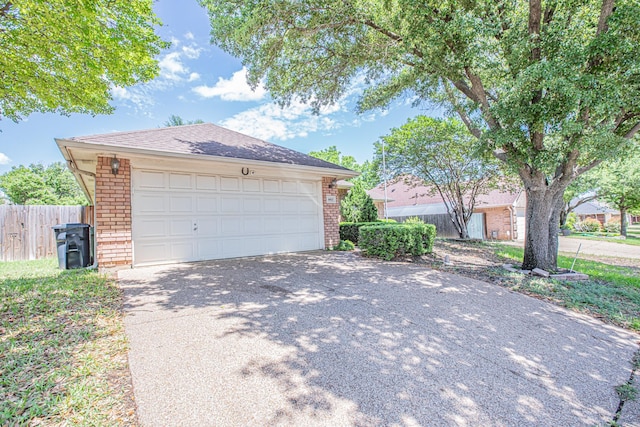 garage featuring fence and driveway