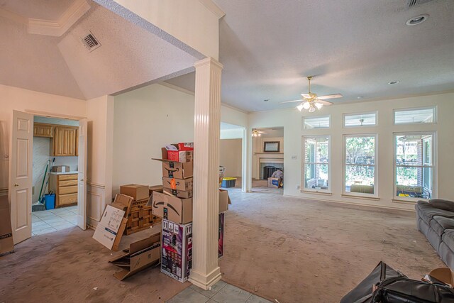 living area with visible vents, ornate columns, light colored carpet, ceiling fan, and a fireplace