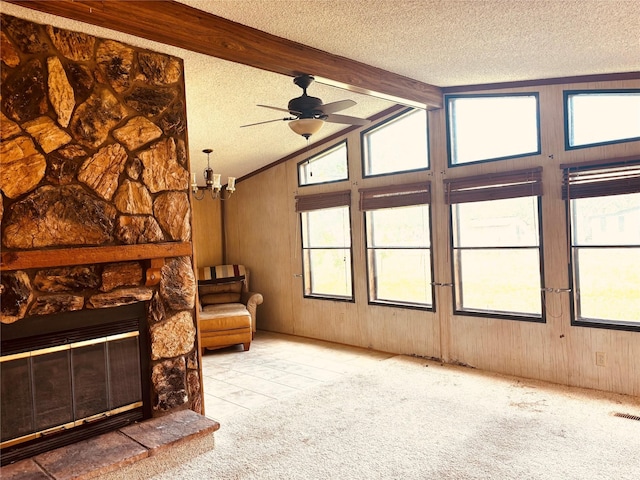 458 Jackson Ave, Strawn, TX 76475 - carpeted living room featuring a textured ceiling, vaulted ceiling with beams, ceiling fan with notable chandelier, wood walls, and a fireplace