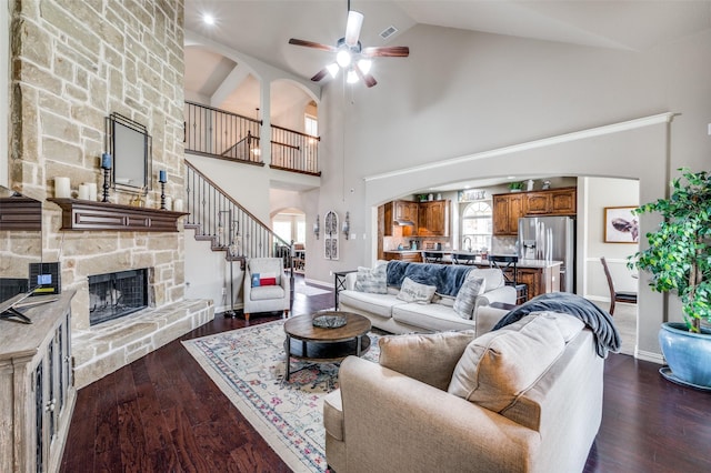 14225 Signal Hill Dr, Little Elm, TX 75068 - living room featuring arched walkways, a ceiling fan, a fireplace, high vaulted ceiling, and dark wood-style flooring