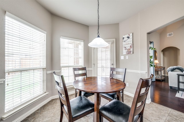 14225 Signal Hill Dr, Little Elm, TX 75068 - dining room featuring arched walkways, plenty of natural light, light tile patterned floors, and baseboards
