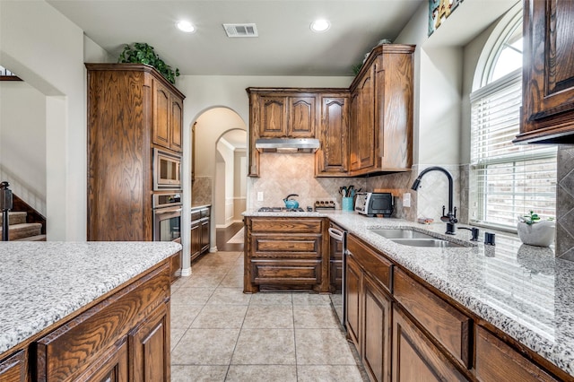 14225 Signal Hill Dr, Little Elm, TX 75068 - kitchen featuring a sink, stainless steel appliances, tasteful backsplash, light stone countertops, and under cabinet range hood
