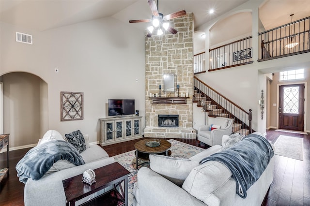 14225 Signal Hill Dr, Little Elm, TX 75068 - living room featuring high vaulted ceiling, wood finished floors, arched walkways, ceiling fan, and a stone fireplace