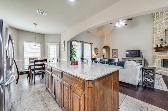 14225 Signal Hill Dr, Little Elm, TX 75068 - kitchen featuring stainless steel fridge with ice dispenser, arched walkways, light tile patterned flooring, ceiling fan, and hanging light fixtures