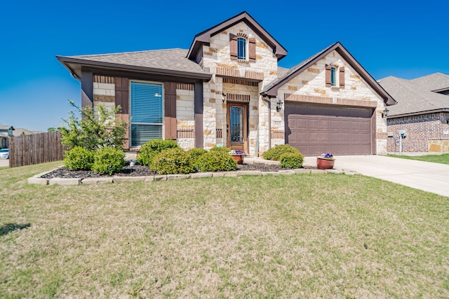 french country home featuring stone siding, a front yard, a garage, and concrete driveway