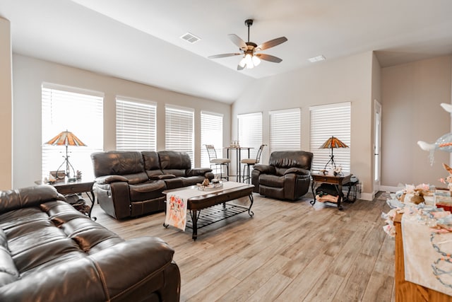 living area featuring vaulted ceiling, light wood-type flooring, visible vents, and a ceiling fan