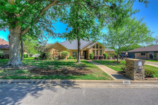 view of front of property featuring brick siding and a front yard
