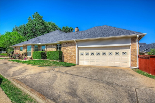 ranch-style home with concrete driveway, a shingled roof, and a garage