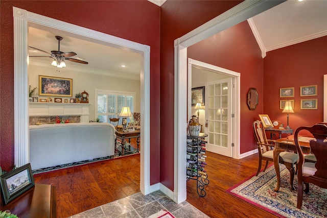 interior space with wood finished floors, crown molding, baseboards, and a ceiling fan