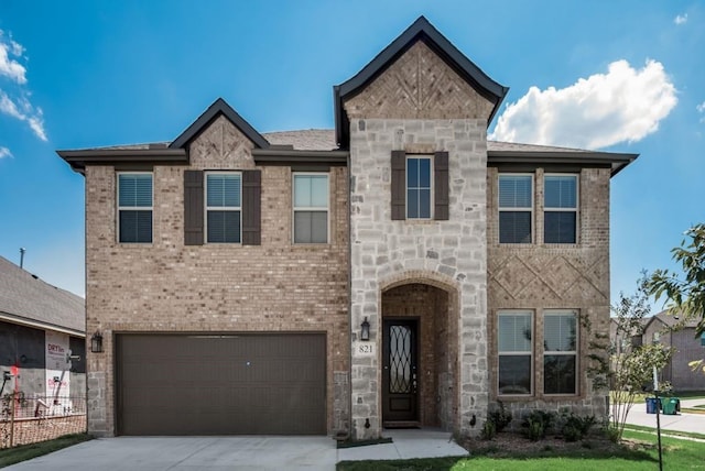 view of front of property with brick siding, an attached garage, stone siding, and concrete driveway