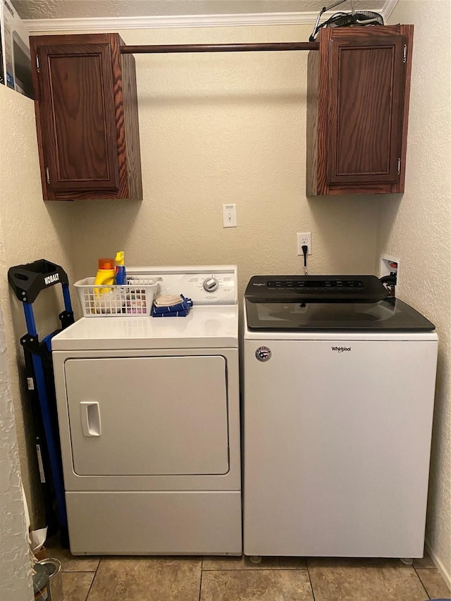 clothes washing area featuring cabinet space, a textured wall, washer and dryer, and light tile patterned floors