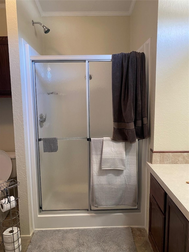 full bath featuring vanity, crown molding, and a stall shower