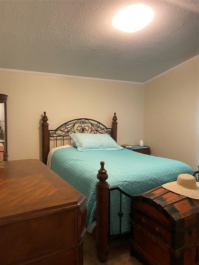 bedroom with a textured ceiling and ornamental molding