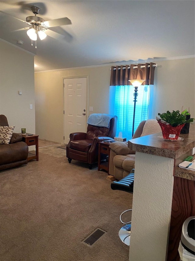 living room with ceiling fan, crown molding, carpet flooring, and visible vents