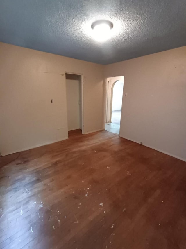 spare room featuring a textured ceiling and light wood finished floors