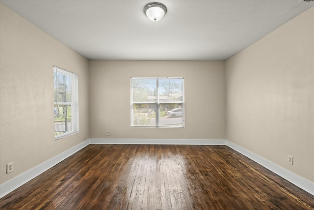 empty room with baseboards and dark wood-style flooring