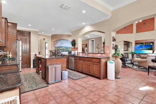 1547 Sandstone Dr, Frisco, TX 75034 - kitchen featuring dark stone countertops, arched walkways, visible vents, and stainless steel appliances