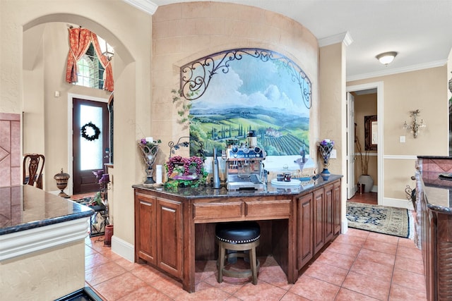 1547 Sandstone Dr, Frisco, TX 75034 - interior space with brown cabinetry, ornamental molding, light tile patterned flooring, and dark stone counters