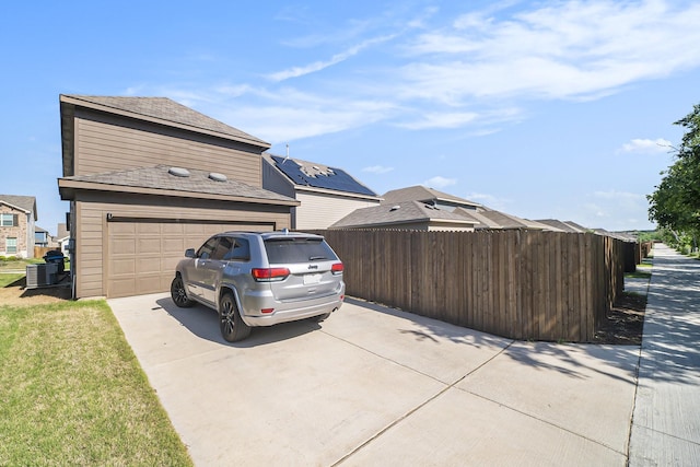 view of home's exterior featuring concrete driveway, fence, and a garage
