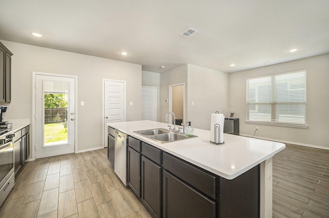 kitchen featuring light countertops, a sink, visible vents, and light wood-style floors