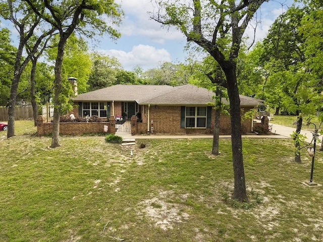 ranch-style home with brick siding, a front lawn, and fence