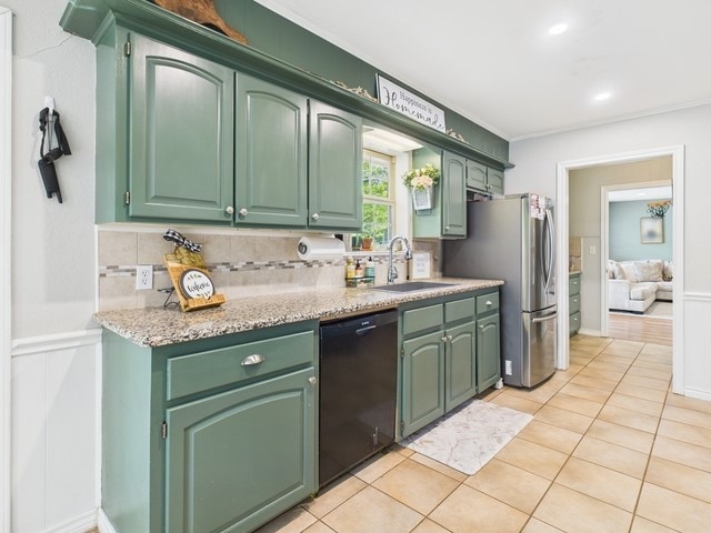 kitchen featuring black dishwasher, freestanding refrigerator, decorative backsplash, and a sink