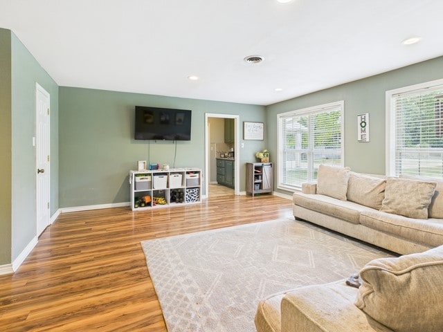 living area featuring recessed lighting, wood finished floors, visible vents, and baseboards