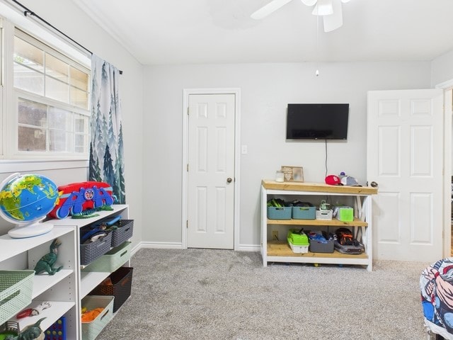 playroom featuring carpet floors, a ceiling fan, and baseboards