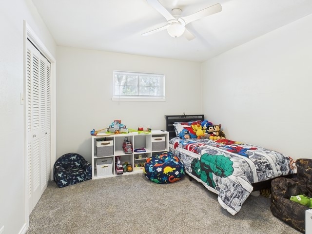 bedroom with a ceiling fan, carpet flooring, and a closet