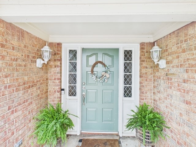 doorway to property featuring brick siding