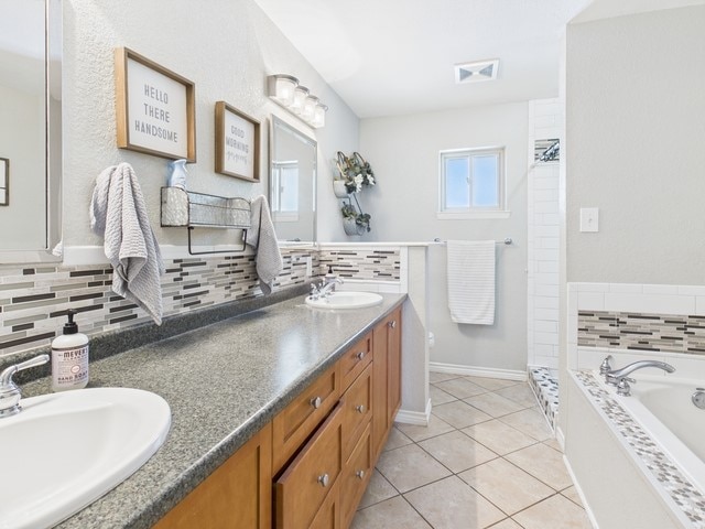 full bath featuring a bath, visible vents, tile patterned floors, and a sink