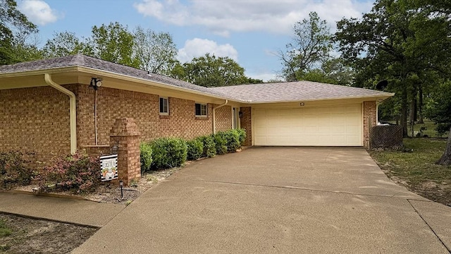 single story home with an attached garage, brick siding, and concrete driveway