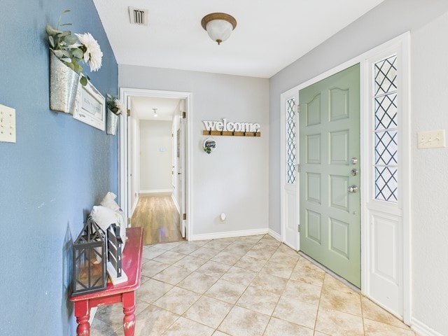 foyer featuring visible vents and light tile patterned floors