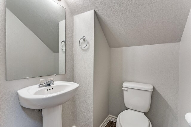 bathroom featuring vaulted ceiling and toilet