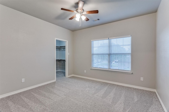 spare room featuring baseboards, visible vents, carpet floors, and ceiling fan