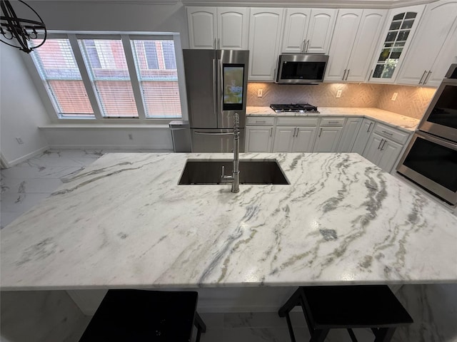 kitchen featuring marble finish floor, glass insert cabinets, appliances with stainless steel finishes, and white cabinets