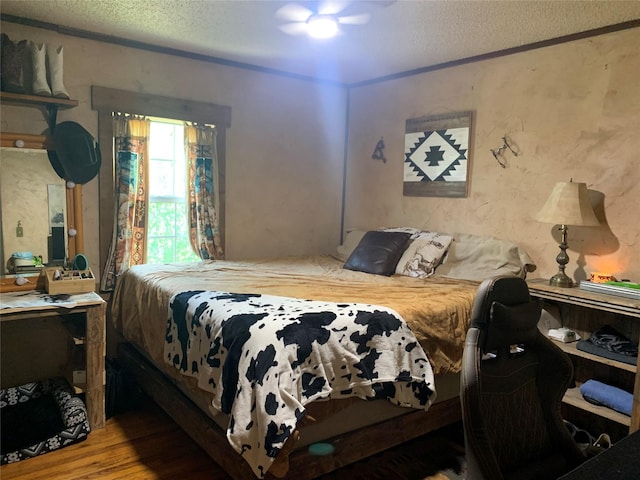 bedroom featuring wood finished floors and a textured ceiling