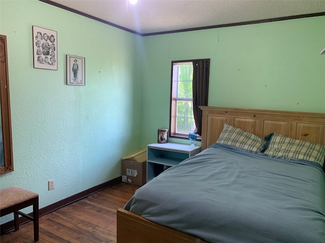 bedroom featuring wood finished floors, a textured ceiling, baseboards, and a textured wall