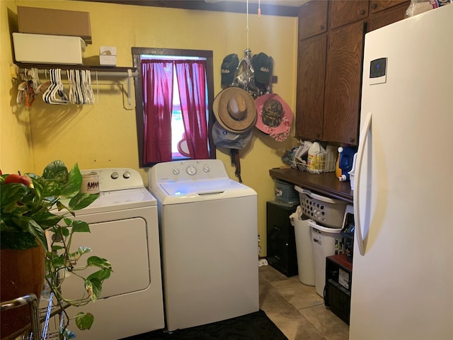 laundry room with light tile patterned floors, cabinet space, and independent washer and dryer